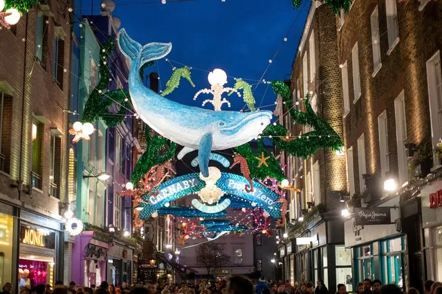 Shoppers make their way as lights of the “Carnaby Project Zero” illuminate Carnaby Street in the Soho district in London, Britain, December 7, 2019. (Photo by Lisi Niesner/Reuters)