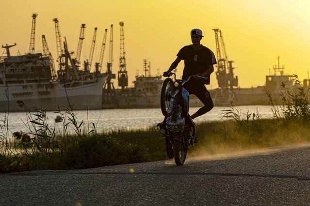 A man rides his motorcycle as the sun sets in Basra, Iraq, Monday, May 9, 2022. (Photo by Nabil al-Jurani/AP Photo)