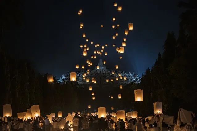 Buddhist devotees and tourists release lanterns into the air on Borobudur temple during celebrations for Vesak Day on May 16, 2022 in Magelang, Central Java, Indonesia. Vesak is observed during the full moon in May or June with the ceremony centering around three Buddhist temples, pilgrims walk from Mendut to Pawon, ending at Borobudur. The holy day celebrates the birth, the enlightenment to nirvana, and the passing of Gautama Buddha's, the founder of Buddhism. (Photo by Ulet Ifansasti/Getty Images)