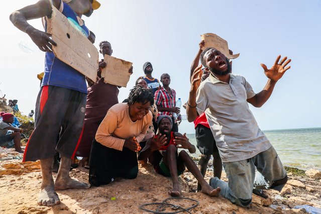 Migrants from Africa, stranded on the seashore at the Libyan-Tunisian border in Ras Jedir, react towards journalists on July 26, 2023. (Photo by Mahmud Turkia/AFP Photo)