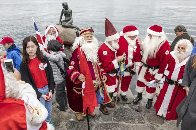 Participants of the Santa Claus World Congress visit the Little Mermaid statue in Copenhagen, Denmark, on July 24, 2017. The first Santa Claus World Congress was held in 1957. Participants from Denmark, Norway, Sweden, Greenland, Spain, Germany, the United States and Japan attend the event. (Photo by Nikolai Linares/AFP Photo/Scanpix Denmark)