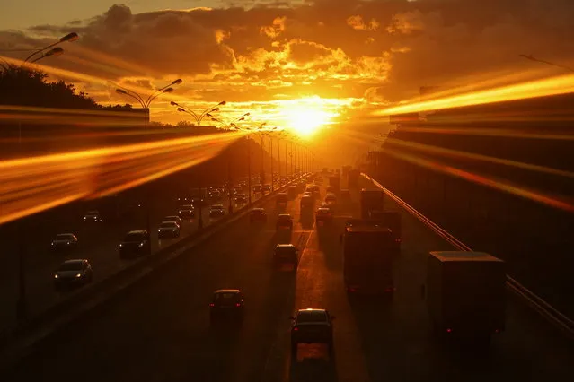 Cars drive along a highway during sunset in Moscow, Russia on June 15, 2022. Picture taken through the window. (Photo by Evgenia Novozhenina/Reuters)