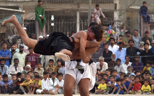 Wrestlers in action during a traditional Sindhi Malakhra wrestling event in Karachi, Pakistan, 31 October 2024. During a Malakhra match, both wrestlers tie twisted cloth around their opponents' waists. They then grab the opponent's waist cloth and attempt to throw him to the ground. (Photo by Shahzaib Akber/EPA/EFE)