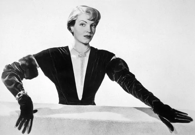 1949: A model wearing fur-trimmed long evening gloves