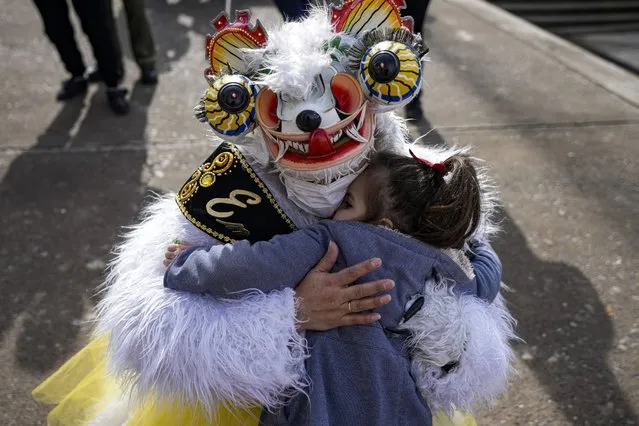 A “La Diablada” dancer embraces a girl during a celebration in honor of the Virgin del Carmen, patron saint of Chile, in Santiago, Chile, Saturday, July 16, 2022. Hundreds of cowboys in woolen ponchos and families on wooden horse carts lined up to receive a priest's blessing in the huge esplanade in front of the National Sanctuary of Maipu on Saturday afternoon. (Photo by Esteban Felix/AP Photo)