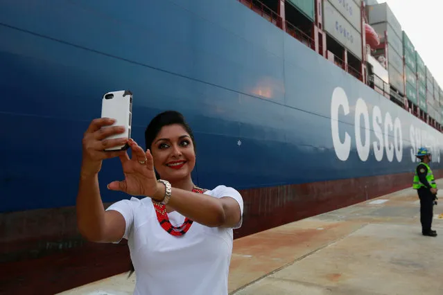 A woman takes a selfie as the Chinese COSCO container vessel is seen crossing the Cocoli locks after crossing the Panama Canal to the Pacific side, during its first ceremonial transit of the new Panama Canal expansion project in Cocoli on the outskirts of Panama City, Panama June 26, 2016. (Photo by Alberto Solis/Reuters)