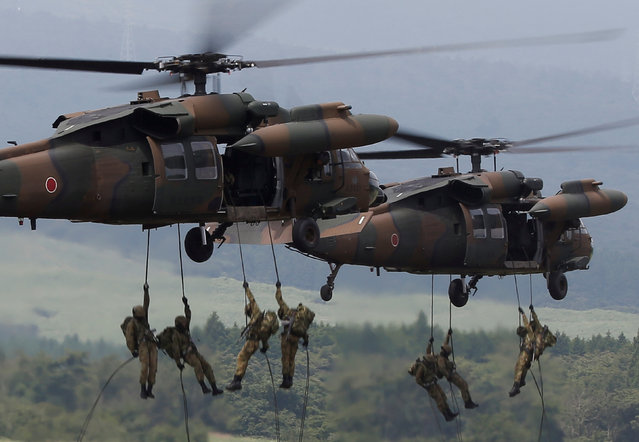 Japanese Ground Self-Defense Force soldiers rappel from UH-60 Black Hawk helicopters during an annual training session near Mount Fuji at Higashifuji training field in Gotemba, west of Tokyo, Japan August 24, 2017. (Photo by Issei Kato/Reuters)