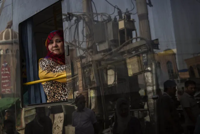 A Uyghur woman looks out the window as she rides in a new bus on August 1, 2014 in old Kashgar, Xinjiang Province, China. (Photo by Kevin Frayer/Getty Images)