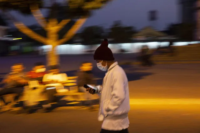 A man wearing a face mask as a precaution against the spread of the new coronavirus, walks near a bus station in Guatemala City, Thursday, March 19, 2020. As part of emergency measures due to the COVID-19 pandemic, the Guatemalan government has restricted public transportation. (Photo by Moises Castillo/AP Photo)