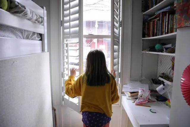Lydia Hassebroek looks out at the view from her window, during her first week of home school after New York State Governor Andrew Cuomo signed an executive order closing New York public schools statewide due to public health concerns over the rapid spread of coronavirus disease (COVID-19) in Brooklyn, New York, U.S., March 19, 2020. (Photo by Caitlin Ochs/Reuters)