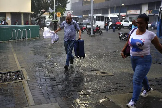 A man runs from the rain in Caracas, Venezuela, Wednesday, June 29, 2022. Forecasters issued a hurricane watch for the Nicaragua-Costa Rica border as a tropical disturbance sped over the southern Caribbean on a path toward Central America. Venezuela shuttered schools, opened shelters and restricted air and water transportation on Wednesday as President Nicolas Maduro noted that the South American country already has been struggling with recent heavy rains. (Photo by Ariana Cubillos/AP Photo)