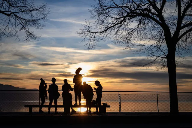 Youngster gather at sunset above Montreux on March 15, 2020. Swiss officials urged people not to be afraid as cases of COVID-19 surged and drastic measures to halt the spread of the virus took hold. On March 13, 2020, the government closed schools and banned public gatherings of more than 100 people and the army said it was preparing to help overstretched hospitals. (Photo by Fabrice Coffrini/AFP Photo)