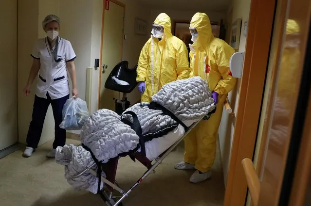 Mortuary employees transport the body of a person in an elderly residence following the coronavirus disease (COVID-19) outbreak in Brussels, Belgium on April 14, 2020. (Photo by Yves Herman/Reuters)
