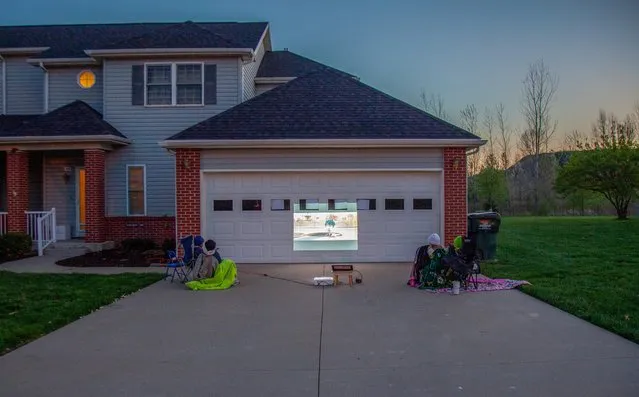 Children Mila and Teo Principe and Alexandria and Juliana Lyles, maintain social distance during an outdoor movie night at a home in Fort Leavenworth, Kansas, April 8, 2020. (Photo by Arin Yoon/Reuters)