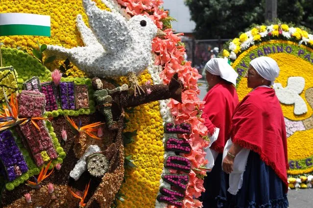 Flower growers, known as silleteros, look at flower arrangements during the annual flower parade in Medellin, Colombia, August 7, 2016. (Photo by Fredy Builes/Reuters)