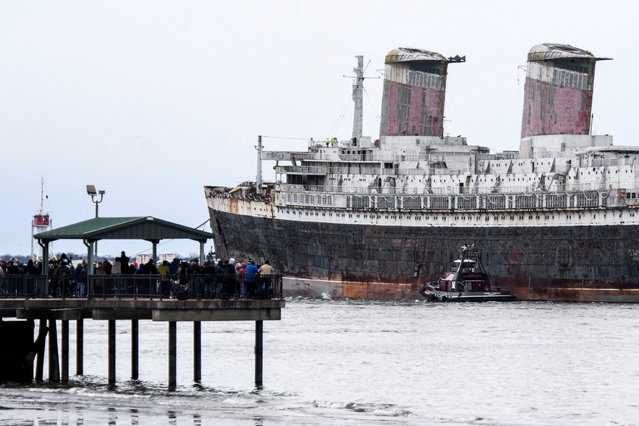Onlookers watch, as SS United States, a retired American ocean liner, that was built during 1950 and 1951 for United States Lines, is towed out to sea on the Delaware River, on her way to Alabama where she is intended to be sunk to create an artificial reef, in Philadelphia, Pennsylvania, U.S., February 19, 2025. (Photo by Matthew Hatcher/Reuters)