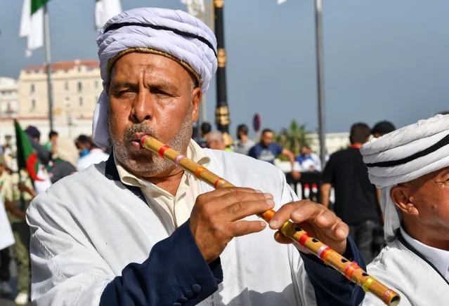 An Algerian musician plays the flute during a parade to mark the anniversary of the Algerian revolution, on October 31, 2022, in the capital Algiers, ahead of tomorrow's Arab summit. Arab leaders are to meet in the Algerian capital tomorrow for their first summit since a string of normalisation deals with Israel that have divided the region. The 22-member Arab League held its last summit in 2019, prior to both the coronavirus pandemic and the UAE's historic US-backed deal establishing diplomatic ties with the Jewish state. (Photo by Fethi Belaid/AFP Photo)