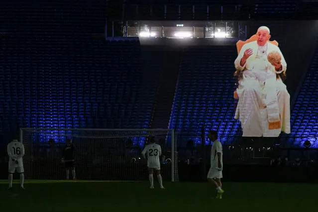 A hologram of Pope Francis addressing a peace message is displayed during a friendly tribute “match for peace” in memory of late Argentininan player Diego Maradona, on November 14, 2022 at the Olympic stadium in Rome. The match is organised by “WePlayForPeace”, a foundation set up by Pope Francis. (Photo by Andreas Solaro/AFP Photo)