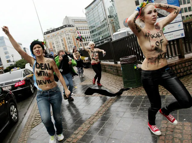 An activist of Ukraine's feminist movement Femen is taken away by the police as she demonstrates by the EU Council building where the EU-Russia summit is taking on December 21, 2012 in Brussels, Belgium. (Photo by Georges Gobet/AFP Photo)