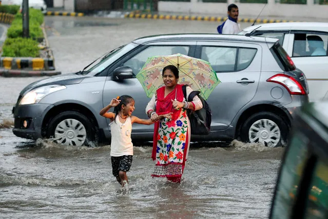 A woman and girl wade across a flooded road during monsoon rains in New Delhi, India August 31, 2016. (Photo by Cathal McNaughton/Reuters)