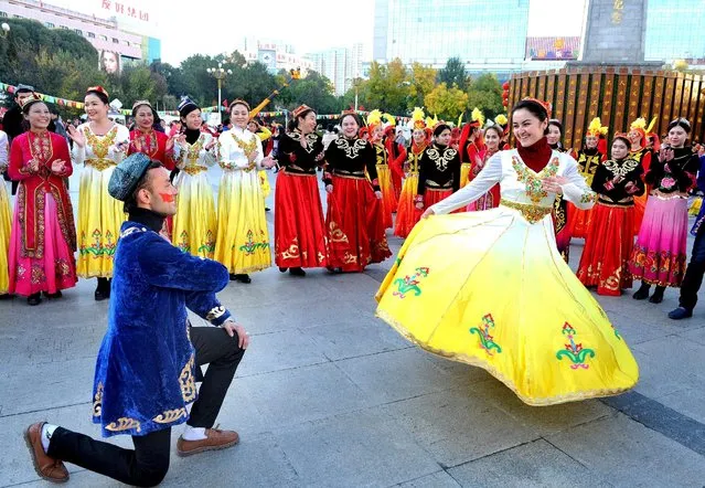 People wearing costumes perform at a square during a celebration on the 60th anniversary of the founding of the Xinjiang Uighur Autonomous Region, in Urumqi, Xinjiang Uighur Autonomous Region, October 1, 2015. (Photo by Reuters/Stringer)