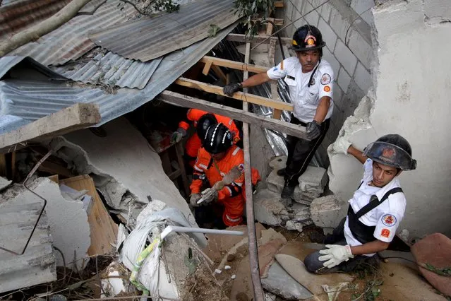 Rescue team members search for mudslide victims in Santa Catarina Pinula, on the outskirts of Guatemala City, October 2, 2015. Hundreds of rescue workers dug through sludge and rock on Friday looking for survivors of a massive mudslide in Guatemala that killed at least nine people and left as many as 600 missing, burying homes in a town on the edge of the capital. (Photo by Josue Decavele/Reuters)