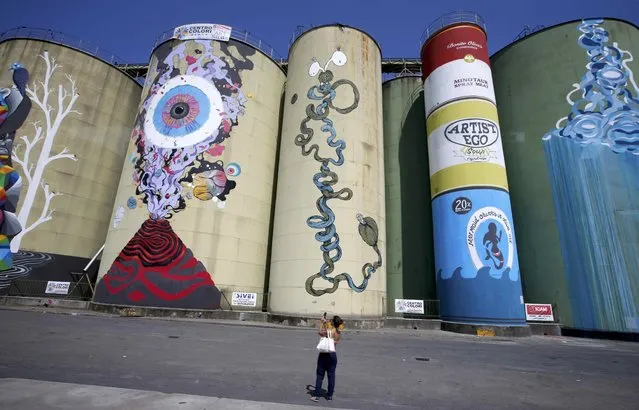 A woman takes a photo of colourfully painted silos called “Street Art silos” which are part of an art festival at the harbour of the Sicilian port city of Catania, Italy, July 4, 2015. (Photo by Fabrizio Bensch/Reuters)