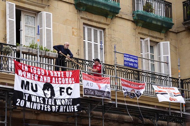 A local resident fending off Manchester United fans who are putting up banners above Plaza Nueva in Bilbao before the UEFA Europa League final at the Estadio de San Mames in Bilbao, Spain on Wednesday, May 21, 2025. (Photo by Nick Potts/PA Images via Getty Images)