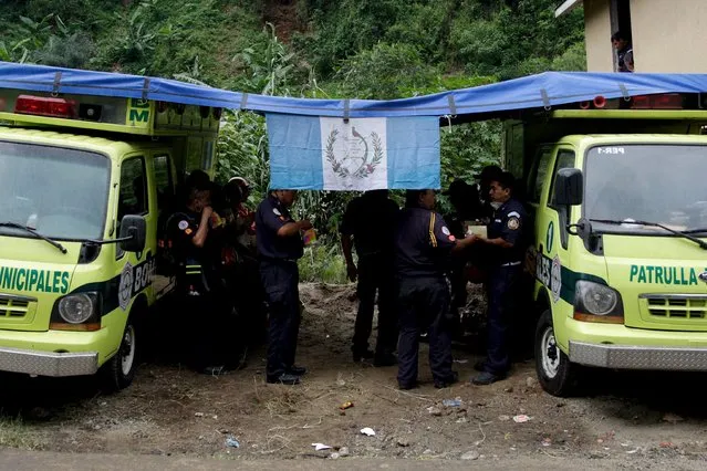 Firefighters take a break to have lunch near an area affected by a mudslide, in Santa Catarina Pinula, on the outskirts of Guatemala City, October 4, 2015. (Photo by Josue Decavele/Reuters)