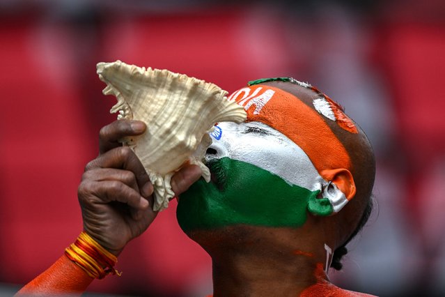 A cricket fan with his face painted in the colours of the Indian flag blows a conch shell during the first day of the fifth and last Test cricket match between India and England at the Himachal Pradesh Cricket Association Stadium in Dharamsala on March 7, 2024. (Photo by Sajjad Hussain/AFP Photo)
