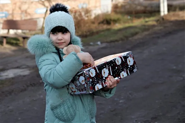 Anhelina, 6, receives a Christmas gift from humanitarian aid organisation UA Future, who are delivering gifts to children living in underground shelters ahead of Orthodox Christmas, as Russia's attack on Ukraine continues, in Bakhmut, Ukraine on January 4, 2023. (Photo by Clodagh Kilcoyne/Reuters)