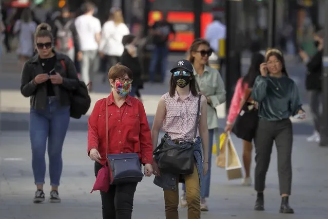 Shoppers wear masks on Oxford Street in London, Monday, Septemner 21, 2020. Britain's top medical advisers have painted a grim picture of exponential growth in illness and death if nothing is done to control the second wave of coronavirus infections, laying the groundwork for the government to announce new restrictions later this week. (Photo by Kirsty Wigglesworth/AP Photo)