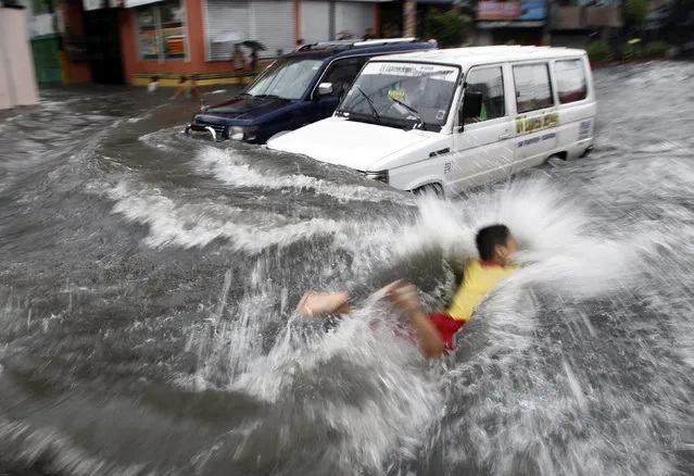 A boy swims in floodwaters brought about by rainfall from Typhoon Muifa in metro Manila, August 2011. (Photo by Romeo Ranoco/Reuters)