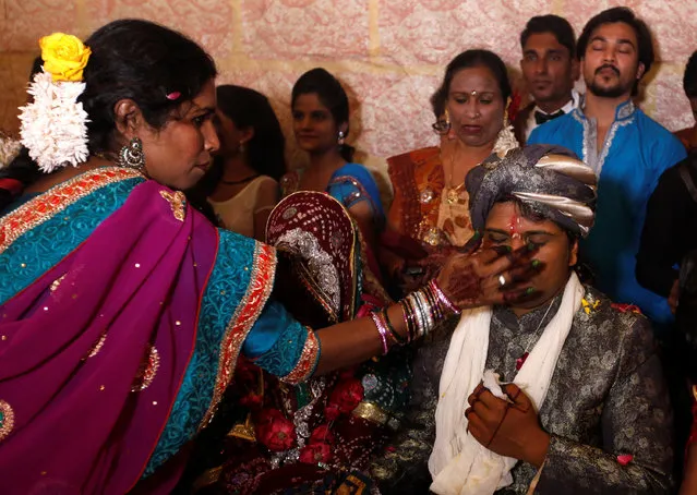 A groom receives a dot on his forehead with Sindoor (red pigment) during a mass marriage ceremony in Karachi, Pakistan, January 24, 2016. (Photo by Akhtar Soomro/Reuters)