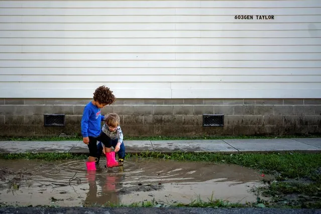 Teagan Marmion, 4, and her neighbor James Smith, 4, play in a puddle after Hurricane Zeta swept through New Orleans, Louisiana, U.S., October 29, 2020. (Photo by Kathleen Flynn/Reuters)