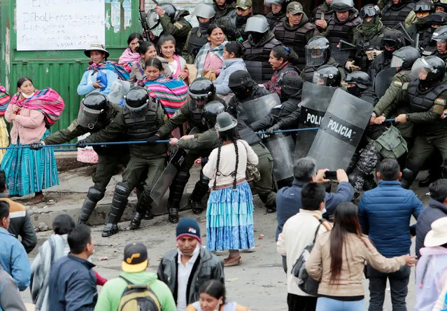 Riot police clash with Bolivian coca growers from Los Yungas region against a bill that caps legal coca crops extensions in La Paz on February 21, 2017. The Bolivian government called coca growers to dialogue, as they have blocked since Saturday the Presidential palace' s access ending in a harsh police repression on Monday night that left at least 40 detainees. (Photo by Manuel Claure/Reuters)