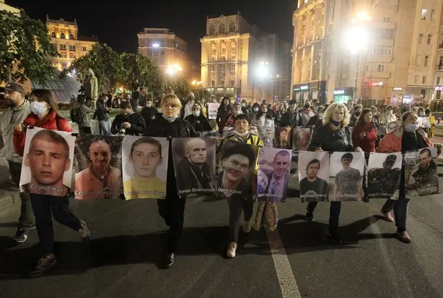 Relatives and friends carry portraits of Ukrainian prisoners, held in eastern Ukraine regions controlled by pro-Russian separatists, during all-Ukrainian action &quot;Remind about everyone&quot; in support of prisoners and relatives of the missing in downtown of Kyiv, Ukraine on 10 October 2020. Hundreds of people, relatives of detainees and missing persons, former prisoners, and supporters held their march rally demand the adoption of a law on captive prisoners and a law on war crimes. (Photo by NurPhoto via Getty Images/Stringer)