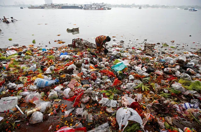 A woman collects items thrown by devotees as religious offerings in the Ganges river, after the celebrations of the last day of Navratri festival, in Kolkata, India, March 26, 2018. (Photo by Rupak De Chowdhuri/Reuters)
