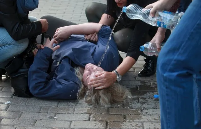 People tend to a woman who fainted after being affected by tear gas during a protest in the centre of Kosovo's capital Pristina, November 18, 2015. Police and protesters clashed in Kosovo for a second day on Wednesday in a deepening crisis over relations with former ruler Serbia. Police fired tear gas at a crowd of around 150 people lobbing rocks, bottles and petrol bombs outside the government building in central Pristina. (Photo by Hazir Reka/Reuters)