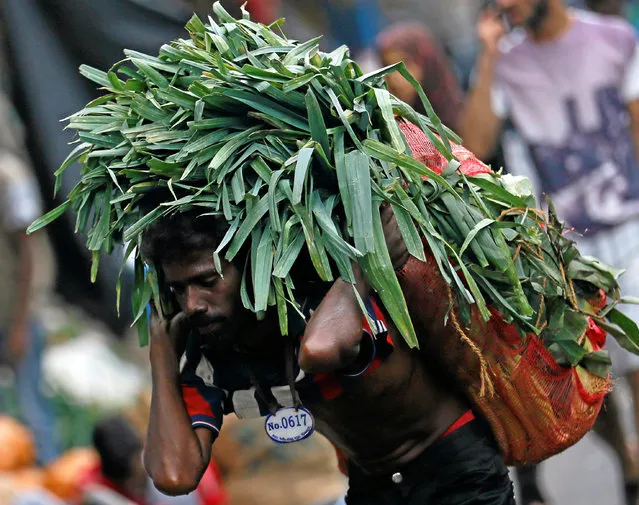 A man carries a sack of vegetables to a stall near a main market in Colombo, Sri Lanka August 31, 2016. (Photo by Dinuka Liyanawatte/Reuters)
