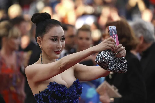 A guest takes a selfie photograph upon arrival at the opening ceremony of the 71st international film festival, Cannes, southern France, Tuesday, May 8, 2018. (Photo by Vianney Le Caer/Invision/AP Photo)