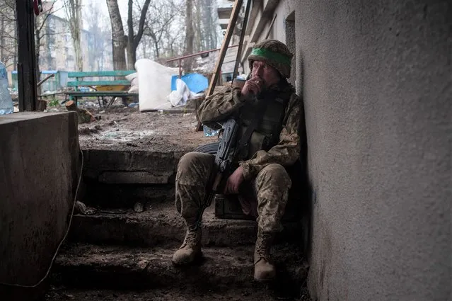 A Ukrainian soldier smokes as he rests in war-hit Bakhmut, Donetsk region, Ukraine, Wednesday, April 12, 2023. (Photo by Iryna Rubakova via AP Photo)