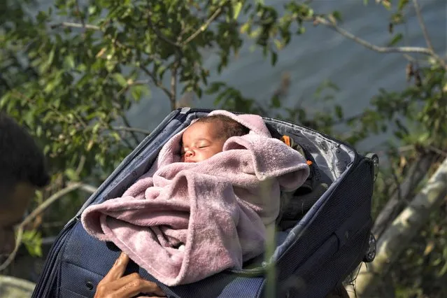 A migrant's baby is carried in a suitcase across the Rio Grande river from  Matamoros, Mexico, Wednesday, May 10, 2023. Migrants rushed across the Mexico border, racing to enter the U.S. before pandemic-related asylum restrictions are lifted in a shift that threatens to put a historic strain on the nation’s beleaguered immigration system. (Photo by Fernando Llano/AP Photo)