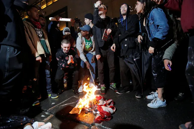Protesters burn a U.S. flag outside Trump Tower following President-elect Donald Trump's election victory in Manhattan, New York, U.S., November 9, 2016. (Photo by Andrew Kelly/Reuters)