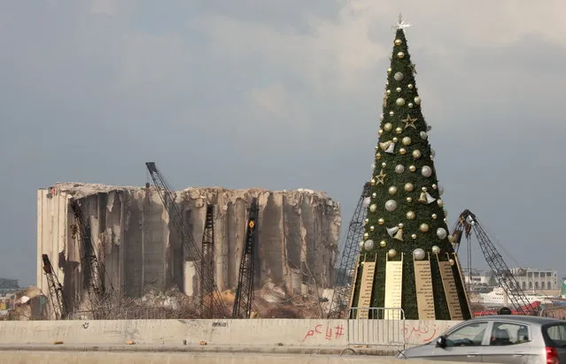 A Christmas tree with names of those who died during Beirut port explosion, is seen near the damaged grain silo, in Beirut, Lebanon on December 22, 2020. (Photo by Mohamed Azakir/Reuters)