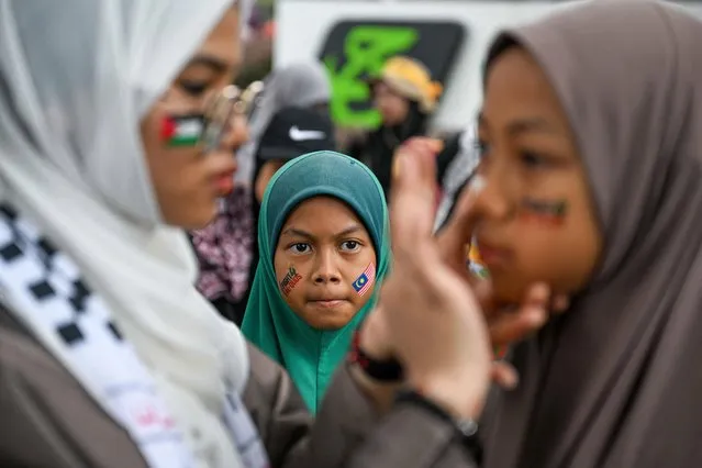 A girl with face pantings (C) looks on during a demonstration to mark al-Quds (Jerusalem) Day, after Friday prayers, in Kuala Lumpur on April 14, 2023. (Photo by Mohd Rasfan/AFP Photo)