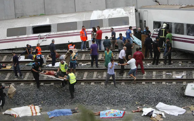 Emergency personnel respond to the scene of a train derailment in Santiago de Compostela, Spain, on Wednesday, July 24, 2013. (Photo by Antonio Hernandez/AP Photo/El correo Gallego)