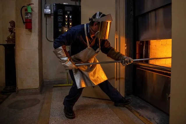 A worker adjusts remains at the Hollywood Forever crematorium as it struggles to keep up with demand during the coronavirus outbreak in Los Angeles, California, March 3, 2021. Cremations at the facility tripled to about 60 in January from the year-ago total. In mid-January, the South Coast Air Quality Management District lifted air quality regulations that limited the number of cremations to protect public health. (Photo by Mike Blake/Reuters)