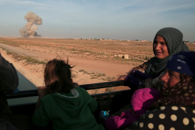 Residents of Hisha return to their town as smoke rises in the background, after the Syrian Democratic Forces (SDF) took control of the area from Islamic State militants, in the northern Raqqa countryside, Syria November 14, 2016. (Photo by Rodi Said/Reuters)
