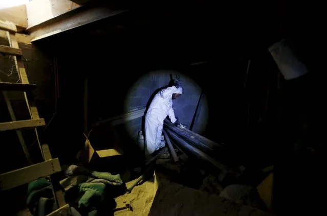 A flashlight illuminates a judicial worker as he shines a torch into an area of the tunnel connected to the Altiplano Federal Penitentiary and used by drug lord Joaquin “El Chapo” Guzman to escape, in Almoloya de Juarez, on the outskirts of Mexico City, Mexico July 14, 2015. (Photo by Edgard Garrido/Reuters)